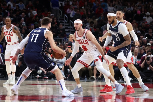 Mavericks guard Luka Doncic (77) dribbles as Bulls guard Alex Caruso (6) defends during the first half at the United Center in Chicago on March 11, 2024.  (Terrence Antonio James/Chicago Tribune)