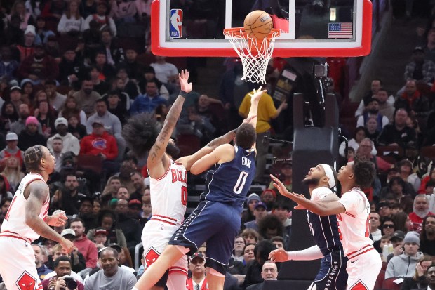 Mavericks guard Dante Exum (0) takes a shot as Bulls guard Coby White (0) defends the first half at the United Center in Chicago on March 11, 2024.  (Terrence Antonio James/Chicago Tribune)