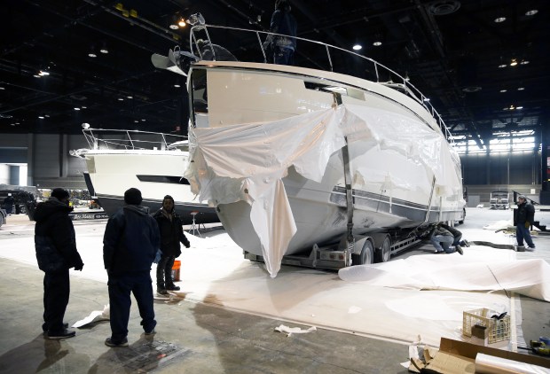 Workers remove protective packaging from a Carver C52 Coupe yacht as preparations continue for the Chicago Boat, RV & Sail Show at McCormick Place in Chicago on January 4, 2018.  (Terrence Antonio James/Chicago Tribune)